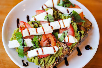 Creamy avocado toast with cherry tomatoes, a quick and easy vegan breakfast."