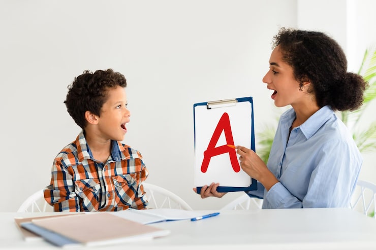 cheerful speech therapist curing boys problems showing letter indoor 116547 76888